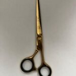 7-inch-professional-barber-scissors-stainless-steel-razor-edge.jpg  "Close-up of professional 7-inch barber scissors with silver stainless steel blades and an ergonomic offset handle."  barber-using-7-inch-shears-for-scissor-over-comb.jpg "Professional barber performing a scissor-over-comb technique using 7-inch hair cutting shears."  razor-edge-hollow-ground-blade-detail.jpg "Macro shot of the hand-honed razor edge on high-carbon steel barber scissors."