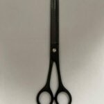 7-inch-professional-barber-scissors-stainless-steel-razor-edge.jpg  "Close-up of professional 7-inch barber scissors with silver stainless steel blades and an ergonomic offset handle."  barber-using-7-inch-shears-for-scissor-over-comb.jpg "Professional barber performing a scissor-over-comb technique using 7-inch hair cutting shears."  razor-edge-hollow-ground-blade-detail.jpg "Macro shot of the hand-honed razor edge on high-carbon steel barber scissors."