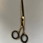7-inch-professional-barber-scissors-stainless-steel-razor-edge.jpg  "Close-up of professional 7-inch barber scissors with silver stainless steel blades and an ergonomic offset handle."  barber-using-7-inch-shears-for-scissor-over-comb.jpg "Professional barber performing a scissor-over-comb technique using 7-inch hair cutting shears."  razor-edge-hollow-ground-blade-detail.jpg "Macro shot of the hand-honed razor edge on high-carbon steel barber scissors."