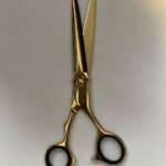 7-inch-professional-barber-scissors-stainless-steel-razor-edge.jpg  "Close-up of professional 7-inch barber scissors with silver stainless steel blades and an ergonomic offset handle."  barber-using-7-inch-shears-for-scissor-over-comb.jpg "Professional barber performing a scissor-over-comb technique using 7-inch hair cutting shears."  razor-edge-hollow-ground-blade-detail.jpg "Macro shot of the hand-honed razor edge on high-carbon steel barber scissors."