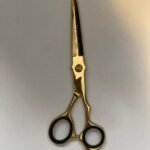 professional-barber-scissors-stainless-steel-razor-edge.jpg  "Close-up of professional 7-inch barber scissors with silver stainless steel blades and an ergonomic offset handle."  barber-using-shears-for-scissor-over-comb.jpg "Professional barber performing a scissor-over-comb technique using 7-inch hair cutting shears."  razor-edge-hollow-ground-blade-detail.jpg "Macro shot of the hand-honed razor edge on high-carbon steel barber scissors."