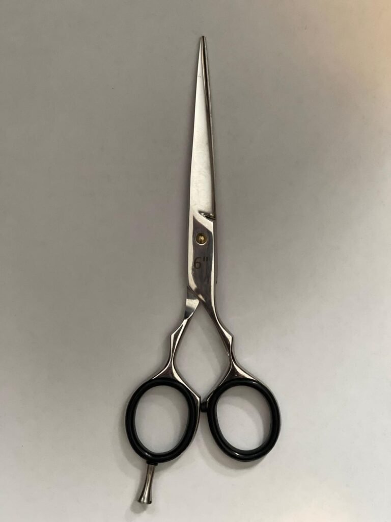 7-inch-professional-barber-scissors-stainless-steel-razor-edge.jpg  "Close-up of professional 7-inch barber scissors with silver stainless steel blades and an ergonomic offset handle."  barber-using-7-inch-shears-for-scissor-over-comb.jpg "Professional barber performing a scissor-over-comb technique using 7-inch hair cutting shears."  razor-edge-hollow-ground-blade-detail.jpg "Macro shot of the hand-honed razor edge on high-carbon steel barber scissors."