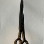 7-inch-professional-barber-scissors-stainless-steel-razor-edge.jpg  "Close-up of professional 7-inch barber scissors with silver stainless steel blades and an ergonomic offset handle."  barber-using-7-inch-shears-for-scissor-over-comb.jpg "Professional barber performing a scissor-over-comb technique using 7-inch hair cutting shears."  razor-edge-hollow-ground-blade-detail.jpg "Macro shot of the hand-honed razor edge on high-carbon steel barber scissors."