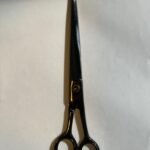 7-inch-professional-barber-scissors-stainless-steel-razor-edge.jpg  "Close-up of professional 7-inch barber scissors with silver stainless steel blades and an ergonomic offset handle."  barber-using-7-inch-shears-for-scissor-over-comb.jpg "Professional barber performing a scissor-over-comb technique using 7-inch hair cutting shears."  razor-edge-hollow-ground-blade-detail.jpg "Macro shot of the hand-honed razor edge on high-carbon steel barber scissors."