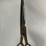 7-inch-professional-barber-scissors-stainless-steel-razor-edge.jpg  "Close-up of professional 7-inch barber scissors with silver stainless steel blades and an ergonomic offset handle."  barber-using-7-inch-shears-for-scissor-over-comb.jpg "Professional barber performing a scissor-over-comb technique using 7-inch hair cutting shears."  razor-edge-hollow-ground-blade-detail.jpg "Macro shot of the hand-honed razor edge on high-carbon steel barber scissors."