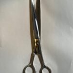 7-inch-professional-barber-scissors-stainless-steel-razor-edge.jpg  "Close-up of professional 7-inch barber scissors with silver stainless steel blades and an ergonomic offset handle."  barber-using-7-inch-shears-for-scissor-over-comb.jpg "Professional barber performing a scissor-over-comb technique using 7-inch hair cutting shears."  razor-edge-hollow-ground-blade-detail.jpg "Macro shot of the hand-honed razor edge on high-carbon steel barber scissors."