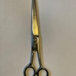 7-inch-professional-barber-scissors-stainless-steel-razor-edge.jpg  "Close-up of professional 7-inch barber scissors with silver stainless steel blades and an ergonomic offset handle."  barber-using-7-inch-shears-for-scissor-over-comb.jpg "Professional barber performing a scissor-over-comb technique using 7-inch hair cutting shears."  razor-edge-hollow-ground-blade-detail.jpg "Macro shot of the hand-honed razor edge on high-carbon steel barber scissors."